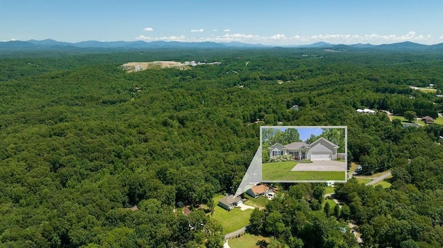 aerial view featuring a forest view and a mountain view