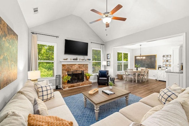 living area with plenty of natural light, a fireplace, visible vents, and dark wood finished floors