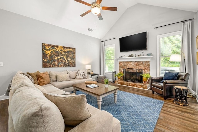 living room featuring a wealth of natural light, a fireplace, wood finished floors, and visible vents