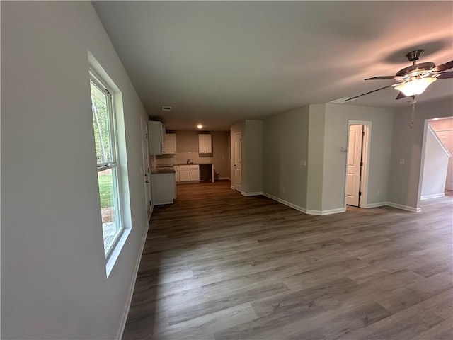 45 Emerald Ln, Covington, GA 30014 - unfurnished living room with baseboards, ceiling fan, and wood finished floors