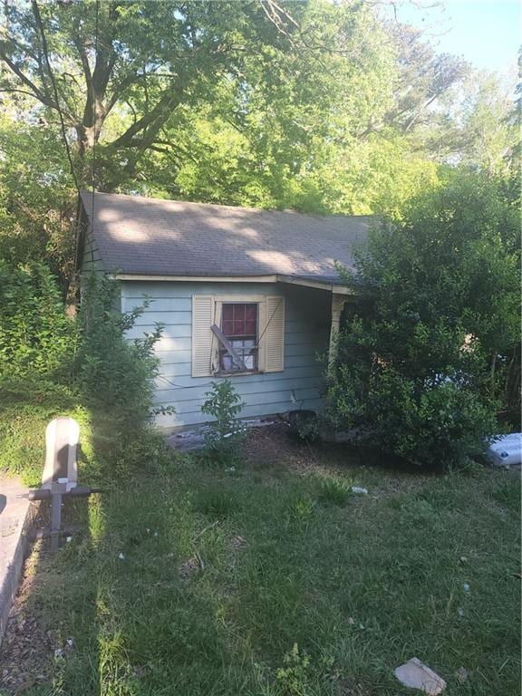 view of property exterior with roof with shingles
