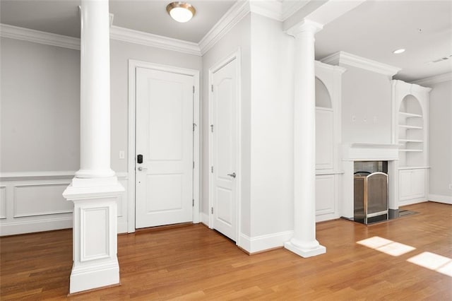 foyer entrance featuring ornate columns, crown molding, and wood-type flooring