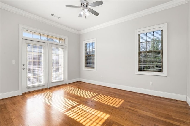 empty room with ceiling fan, ornamental molding, and wood-type flooring