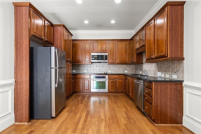 kitchen featuring sink, decorative backsplash, light hardwood / wood-style flooring, and stainless steel appliances