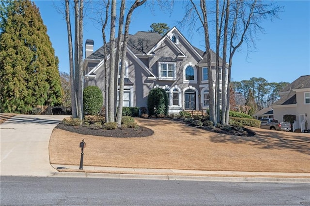 view of front facade featuring driveway and a chimney