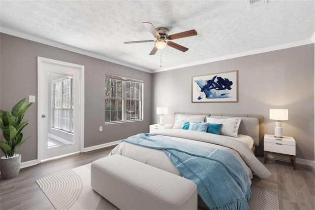 bedroom with wood finished floors, baseboards, a textured ceiling, crown molding, and access to outside