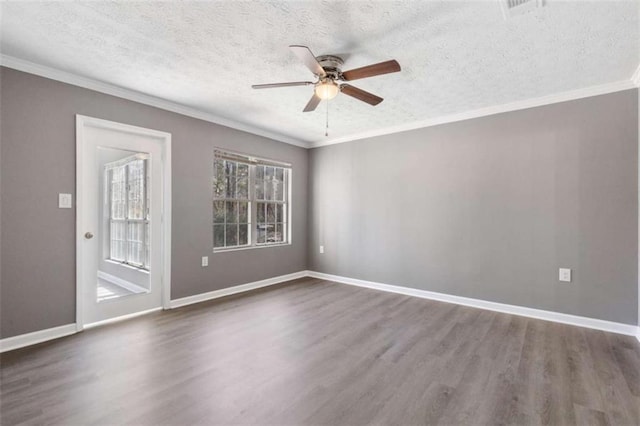 empty room featuring crown molding, wood finished floors, baseboards, and ceiling fan