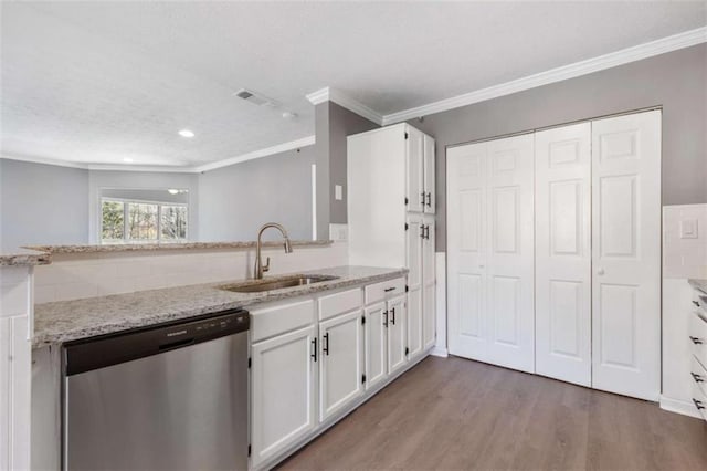 kitchen with a sink, stainless steel dishwasher, wood finished floors, and white cabinetry