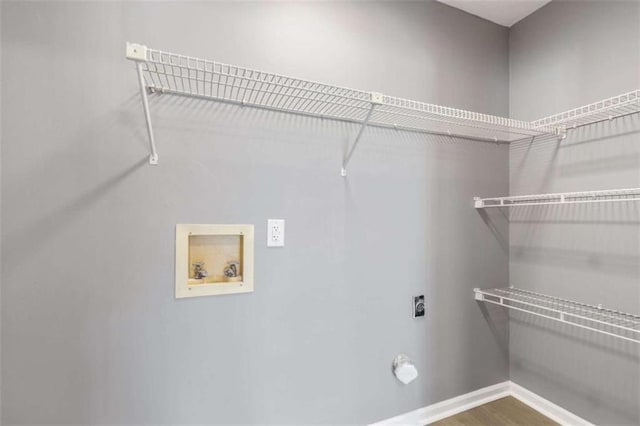 laundry area with hookup for a washing machine, wood finished floors, baseboards, hookup for an electric dryer, and laundry area