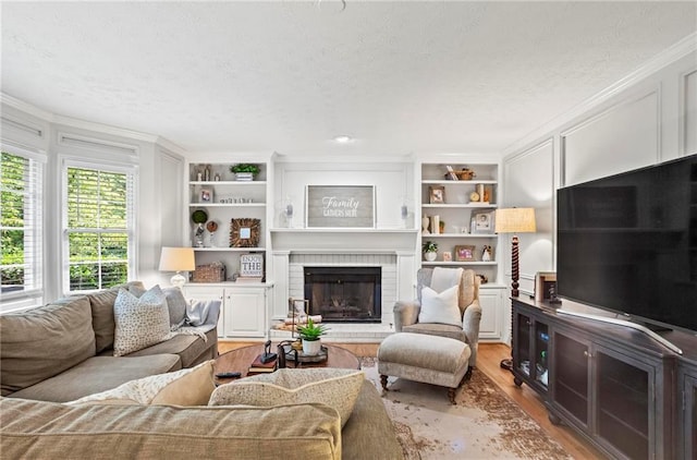 4792 Fairville Ct, Marietta, GA 30062 - living area featuring crown molding, light wood-type flooring, a textured ceiling, a fireplace, and built in features