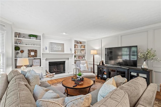 4792 Fairville Ct, Marietta, GA 30062 - living area with a fireplace, a decorative wall, wood finished floors, built in features, and crown molding