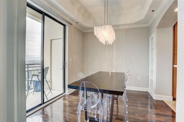 dining room featuring crown molding, dark hardwood / wood-style floors, an inviting chandelier, and a tray ceiling