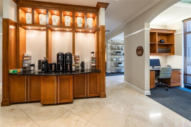 bar with crown molding, built in desk, and light colored carpet