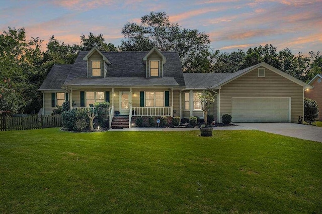 cape cod-style house featuring covered porch, a garage, and a yard