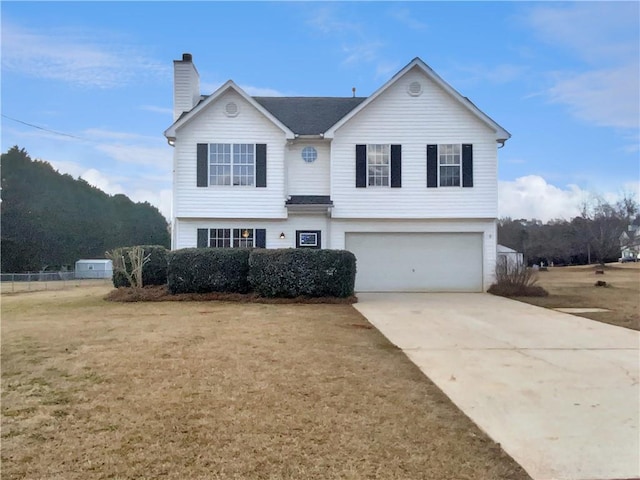 view of front facade featuring a chimney, driveway, an attached garage, and a front lawn