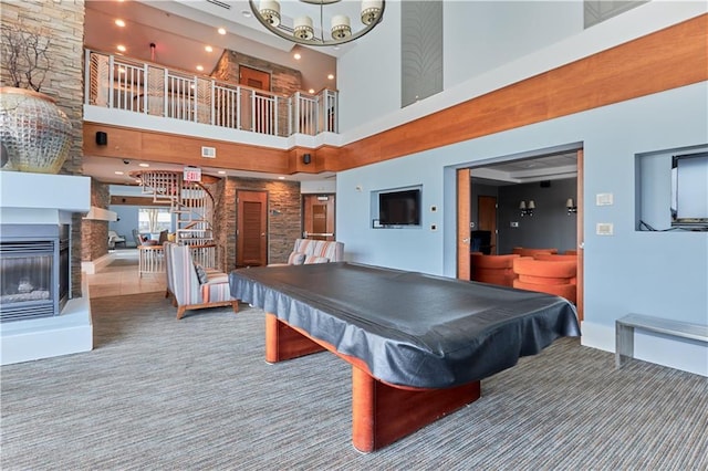 playroom with an inviting chandelier, pool table, a multi sided fireplace, carpet, and a high ceiling