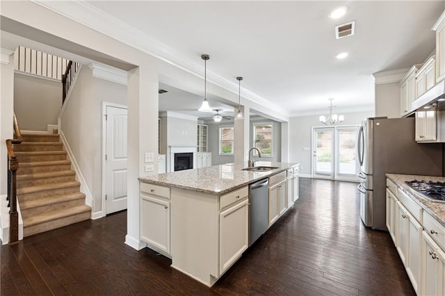 4090 Danbury Farms Dr, Cumming, GA 30040 - kitchen with a sink, appliances with stainless steel finishes, a fireplace, dark wood-type flooring, and a kitchen island with sink
