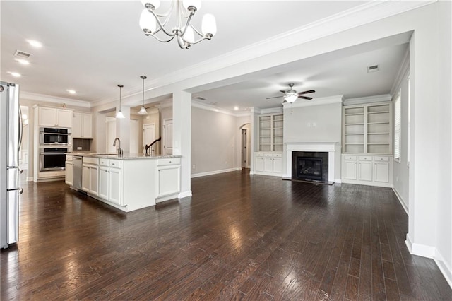 4090 Danbury Farms Dr, Cumming, GA 30040 - living area featuring baseboards, a glass covered fireplace, a ceiling fan, a chandelier, and dark wood-type flooring