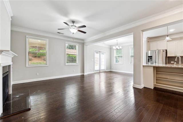 4090 Danbury Farms Dr, Cumming, GA 30040 - unfurnished living room with a chandelier, a ceiling fan, a fireplace, plenty of natural light, and crown molding