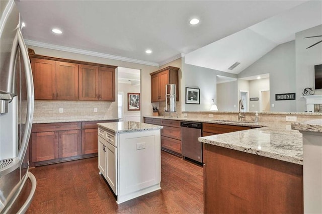 kitchen featuring dark wood-type flooring, stainless steel appliances, light stone counters, vaulted ceiling, and decorative backsplash