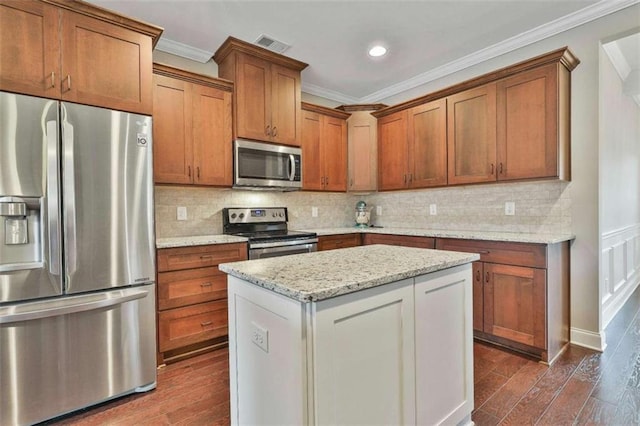 kitchen with stainless steel appliances, light stone counters, and ornamental molding