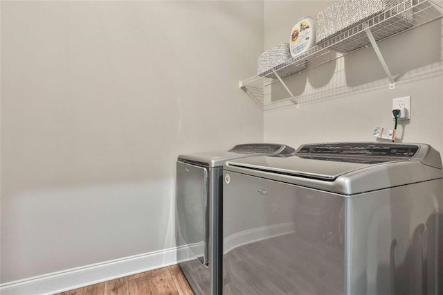 clothes washing area featuring hardwood / wood-style floors and independent washer and dryer