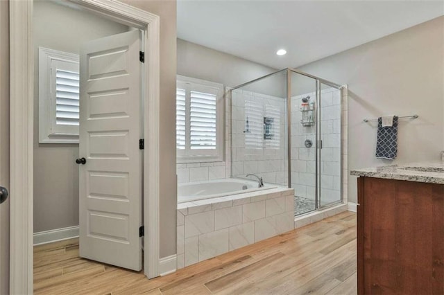 bathroom with vanity and shower with separate bathtub