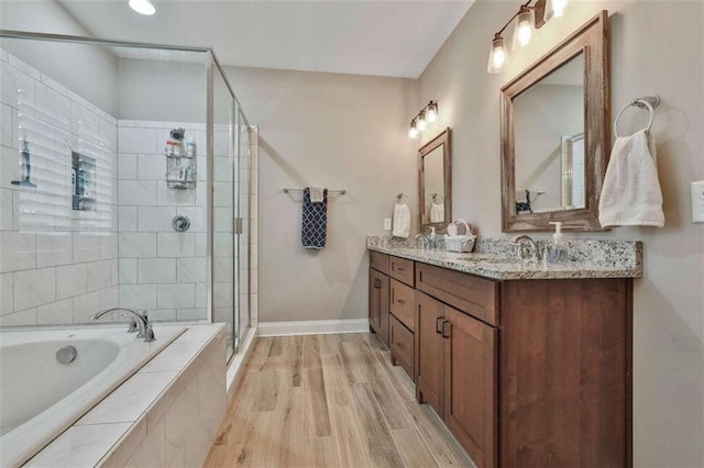 bathroom with vanity, hardwood / wood-style flooring, and independent shower and bath