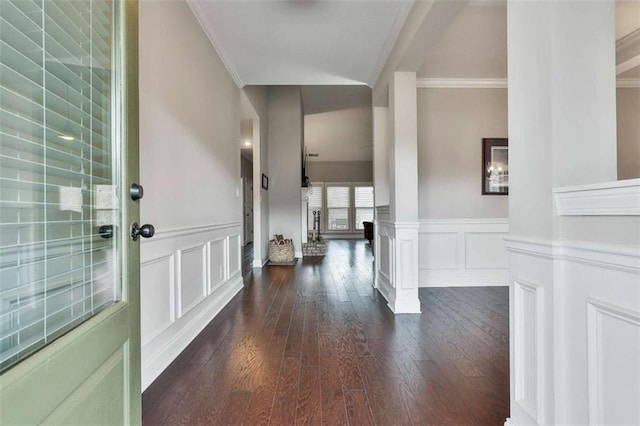 foyer entrance featuring ornate columns, crown molding, and dark wood-type flooring