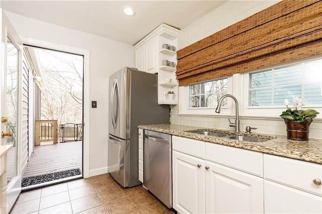 kitchen with light stone counters, sink, stainless steel appliances, and white cabinets