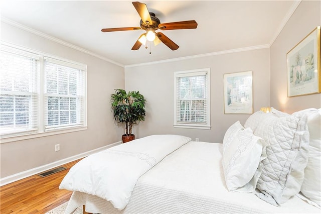 bedroom with hardwood / wood-style flooring, ornamental molding, and ceiling fan