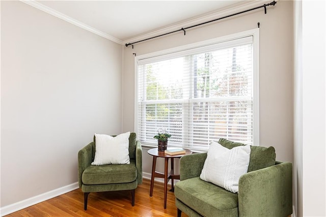 sitting room with crown molding and hardwood / wood-style flooring