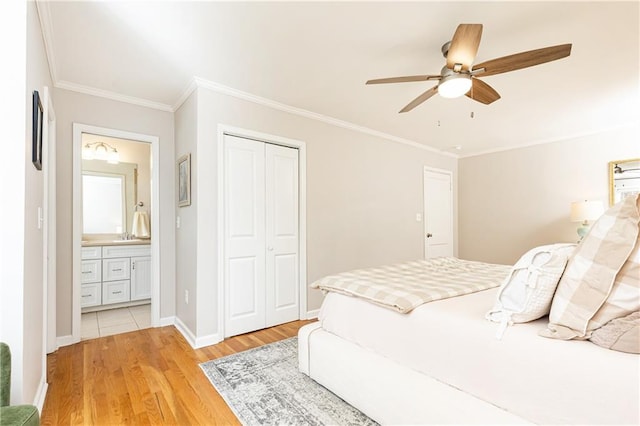 bedroom featuring ensuite bath, ceiling fan, ornamental molding, light hardwood / wood-style floors, and a closet