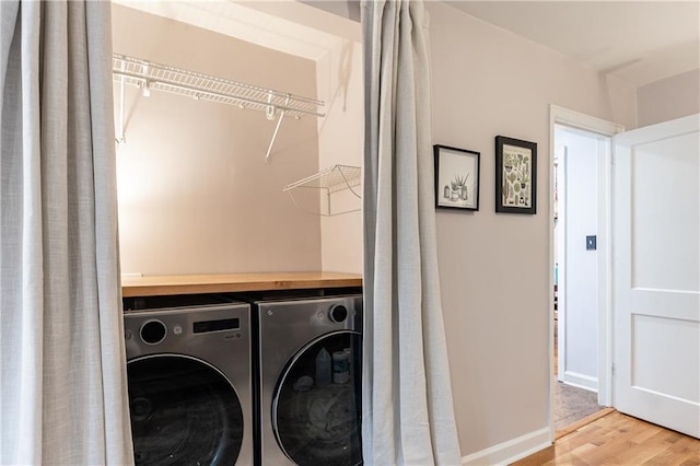 laundry room featuring separate washer and dryer and hardwood / wood-style floors