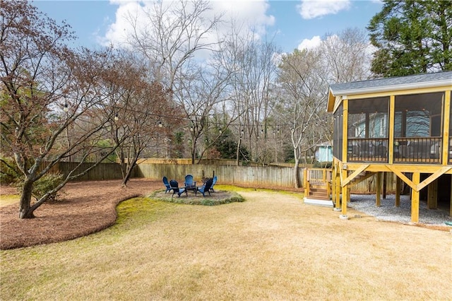 view of yard featuring an outdoor fire pit and a sunroom