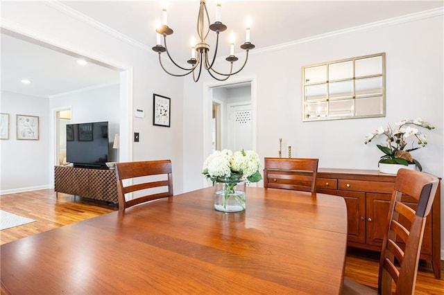 dining space featuring crown molding, a chandelier, and hardwood / wood-style floors