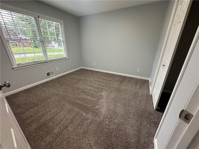unfurnished bedroom featuring baseboards and dark carpet