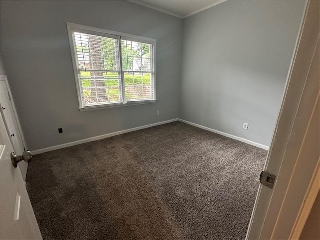 carpeted empty room featuring baseboards and ornamental molding