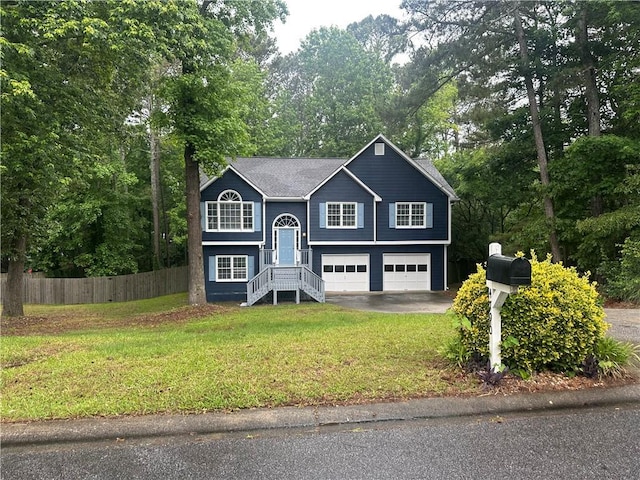 bi-level home with asphalt driveway, an attached garage, and view of scattered trees