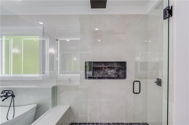 bathroom with a shower stall and a freestanding tub