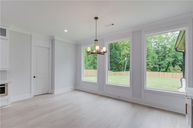 unfurnished dining area featuring visible vents, baseboards, light wood-style flooring, recessed lighting, and a notable chandelier