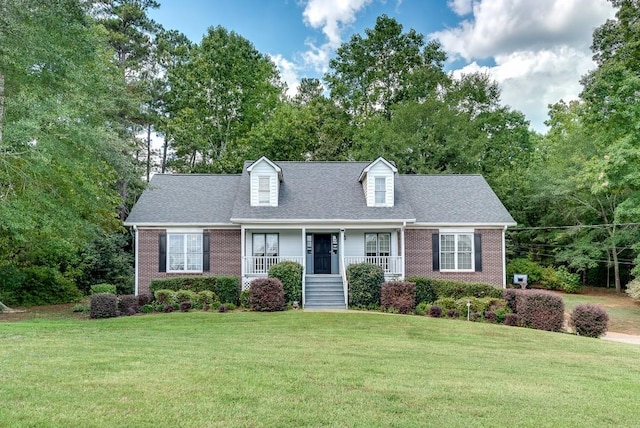 cape cod home with covered porch and a front yard