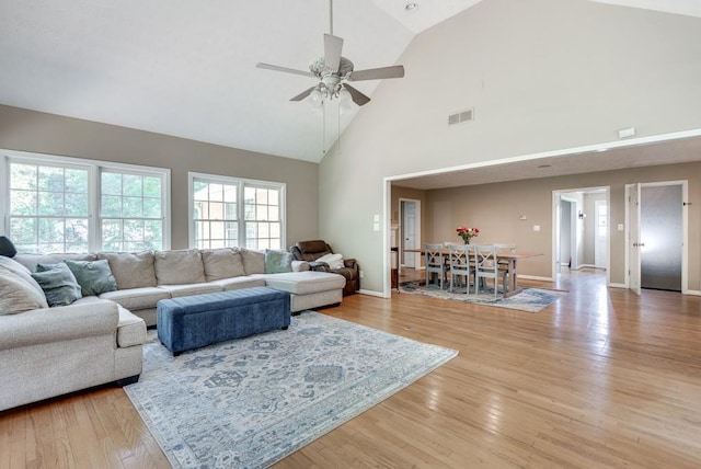 living room featuring ceiling fan, light wood-type flooring, and high vaulted ceiling