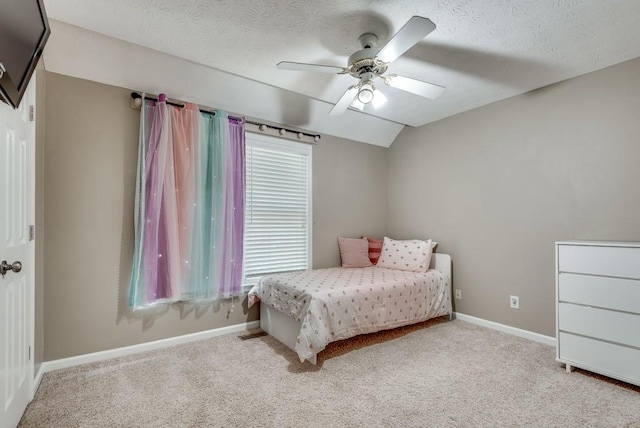 carpeted bedroom with ceiling fan, a textured ceiling, and vaulted ceiling