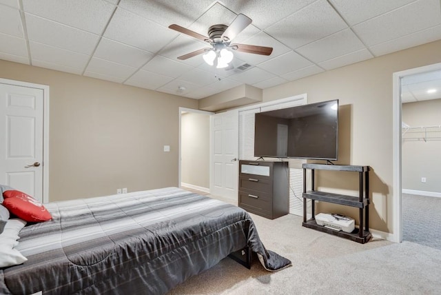 carpeted bedroom featuring a drop ceiling and ceiling fan