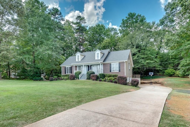 cape cod home featuring covered porch and a front lawn