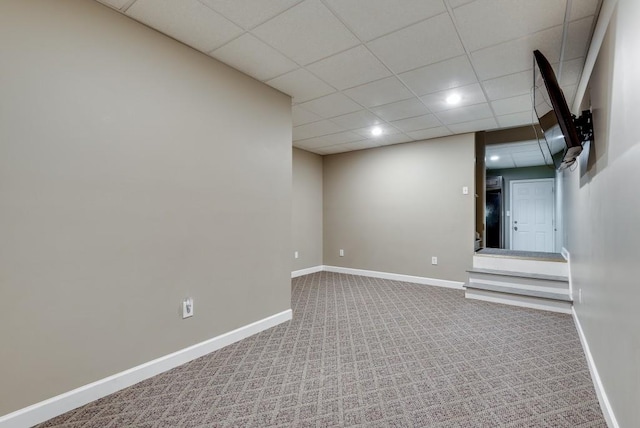 basement featuring a paneled ceiling and carpet