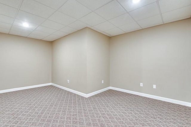 spare room with a paneled ceiling and carpet