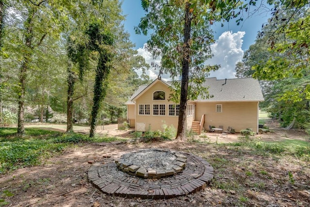 rear view of property with a fire pit