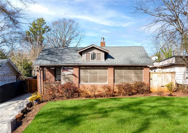 view of front of property with a front yard and a sunroom